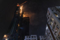 A fire burns at a construction site in Hong Kong, Friday, March 3, 2023.Hong Kong firefighters are battling the blaze that broke out at a construction site in the city's popular shopping district. (AP Photo/Louise Delmotte)