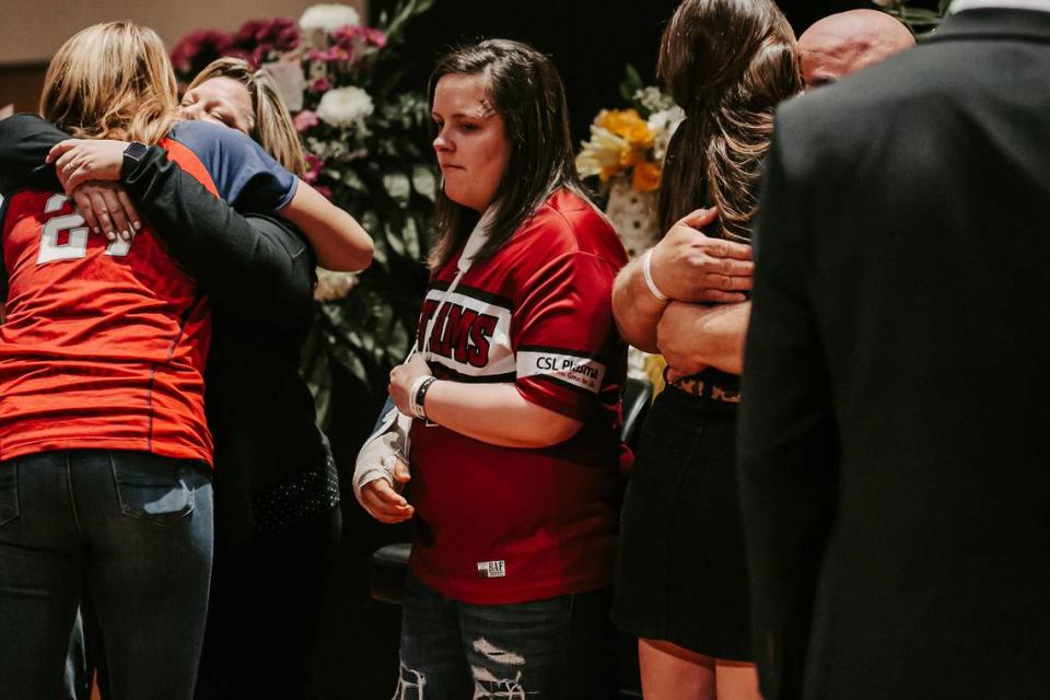 Mallory Stokes (center) at her twin sister Mia’s funeral in February 2020. To the left, former Team USA star pitcher Jennie Finch, who had befriended the Stokes twins and spoke at the funeral, hugs Holly Stokes, the twins’ mother.