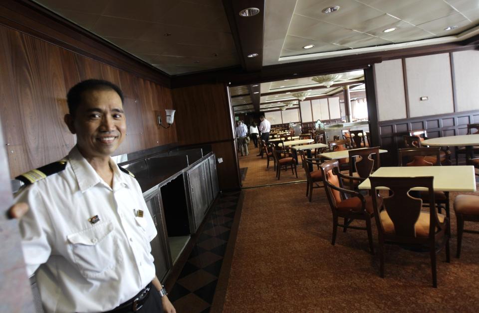 Chief steward, Ronald Gelmo, welcomes visitors to the Queen Elizabeth 2 as Istithmar World, the Dubai state investment company that owns the ship, outlined plans Monday to turn the retired cruise liner into a 300-room hotel, ending years of speculation about its fate, in Port Rashid, Dubai, United Arab Emirates, Monday, July 2, 2012. Britain's Queen Elizabeth II launched the QE2 in 1967. (AP Photo/Kamran Jebreili)