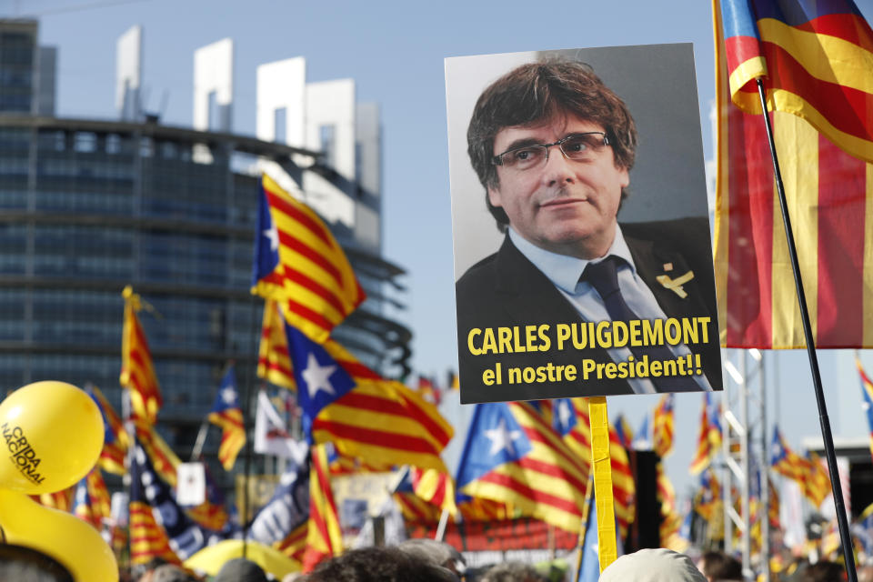 FILE - Demonstrators hold a poster of former Catalan regional president Carles Puigdemont outside the European Parliament in Strasbourg, eastern France, on July 2, 2019. Nearly six years ago, the leader of Catalonia's failed secession bid slipped secretly across the Spanish border to escape arrest and start a life of a self-styled political exile. Now, Carles Puigdemont, after eluding repeated extradition attempts by Spanish justice, has the future of Spain’s government in his hands. (AP Photo/Jean-Francois Badias, File)