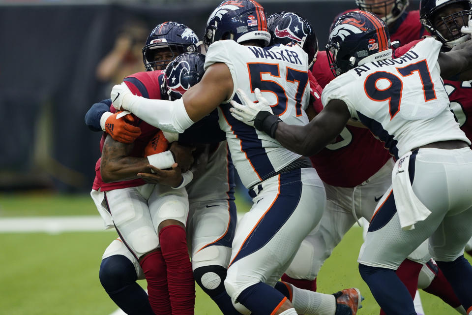 Houston Texans quarterback Deshaun Watson, left, is swarmed by Denver Broncos defenders during the first half of an NFL football game Sunday, Dec. 8, 2019, in Houston. (AP Photo/David J. Phillip)