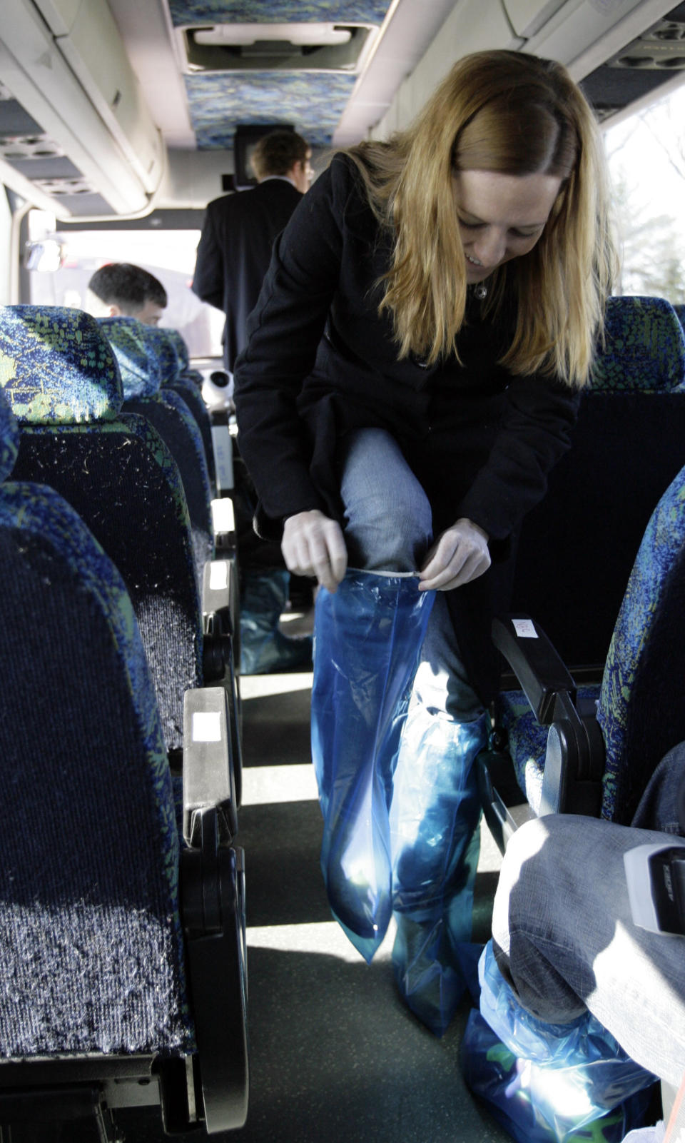 FILE - Jen Psaki, traveling press secretary for Democratic presidential hopeful Sen. Barack Obama D-Ill., puts on protective footwear covers before touring the dairy complex and barns of Penn State University in University Park , Pa., on March 30, 2008. (AP Photo/Alex Brandon, File)