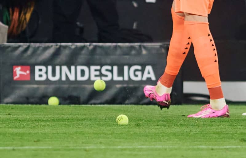 Dortmund goalkeeper Gregor Kobel kicks tennis balls from the pitch that fans have thrown onto the pitch in protest against investors in the DFL during the German Bundesliga soccer match between  Borussia Dortmund and SC Freiburg at Signal Iduna Park. German fan spokesman Thomas Kessen won't guarantee an end of protests after the German Football League (DFL) abandoned plans to bring in a strategic partner but he doesn't expect any further match interruptions. Bernd Thissen/dpa