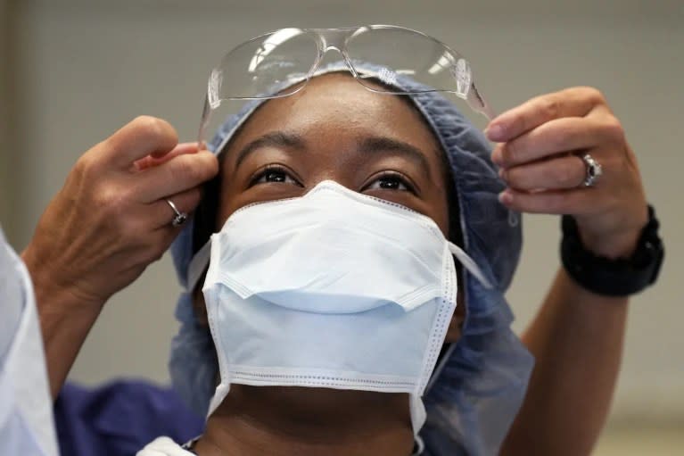 Meharry Medical College student Teresa Belledent gets help putting on her eye protection as she watches an organ procurement surgery June 15, 2023, in Jackson, Tenn. (AP Photo/Mark Humphrey)