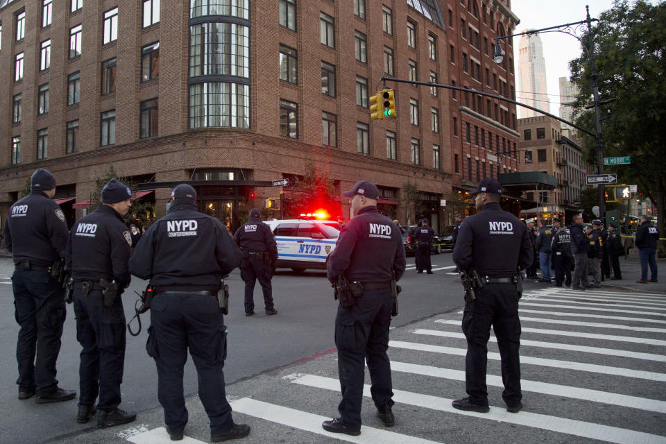 Police stand watch near a building associated with Robert De Niro in New York on Thursday. (Photo: Mark Lennihan/AP)