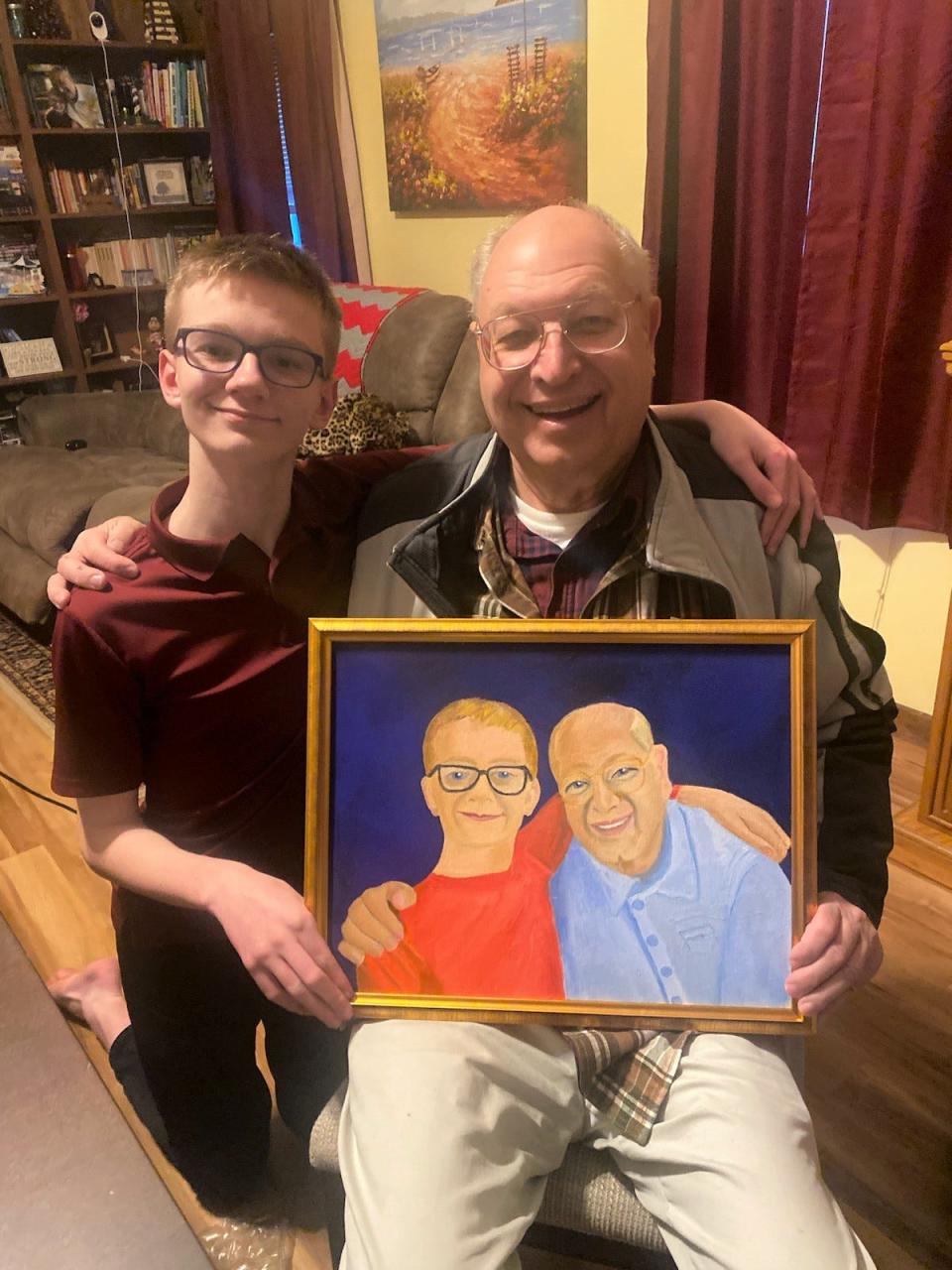 David Weichenthal, right, poses with his grandson, Alexander Simpkins. They are holding a painting done of them by artist Dorothy Weichenthal.