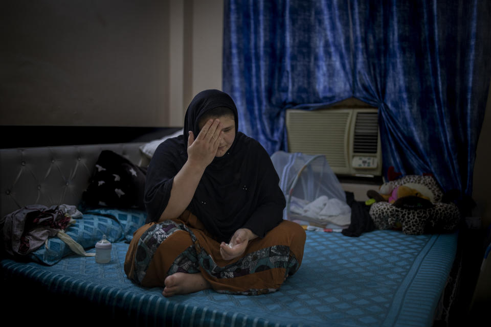 Refugee and former Afghan policewoman Khatera Hashmi sits inside a rented accommodation in New Delhi, India on Aug. 13, 2021. When the Taliban shot policewoman Khatira Hashmi and gouged out her eyes, she knew Afghanistan was no longer safe. Along with her husband, she fled to India last year. She was shot multiple times on her way home from work last October in the capital of Ghazni province, south of Kabul. As she slumped over, one of the attackers grabbed her by the hair, pulled a knife and gouged out her eyes. (AP Photo/Altaf Qadri)