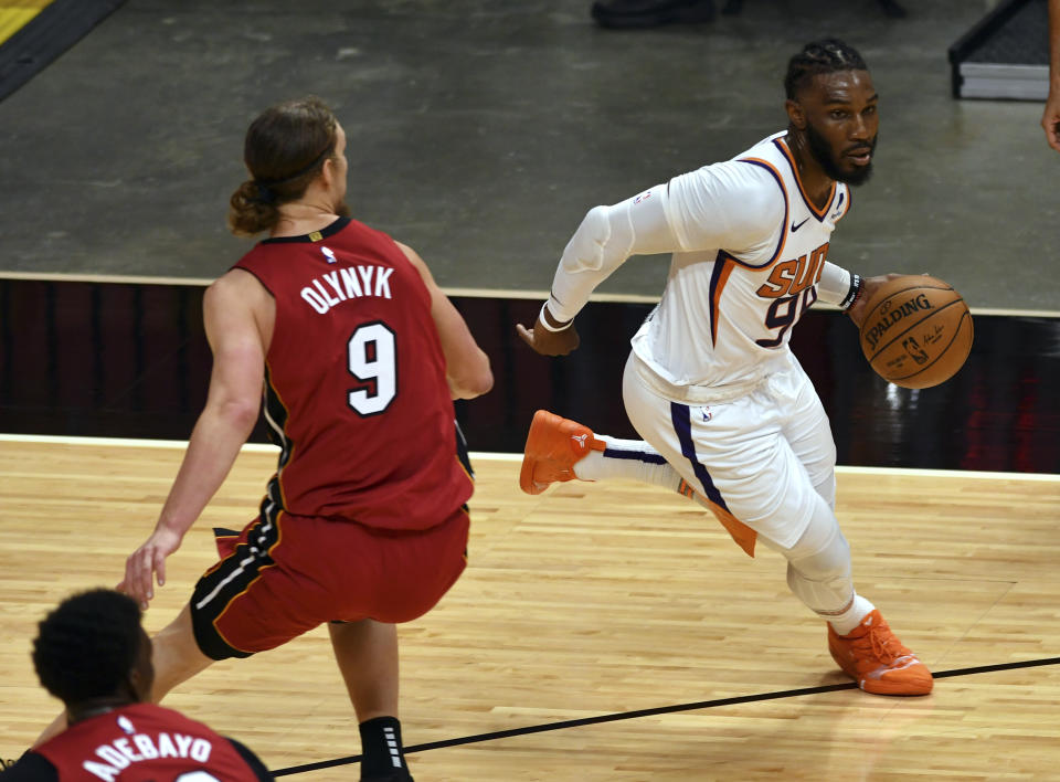 Phoenix Suns forward Jae Crowder (99) drives past Miami Heat forward Kelly Olynyk (9) during the second half of an NBA basketball game Tuesday, March 23, 2021, in Miami. (AP Photo/Jim Rassol)