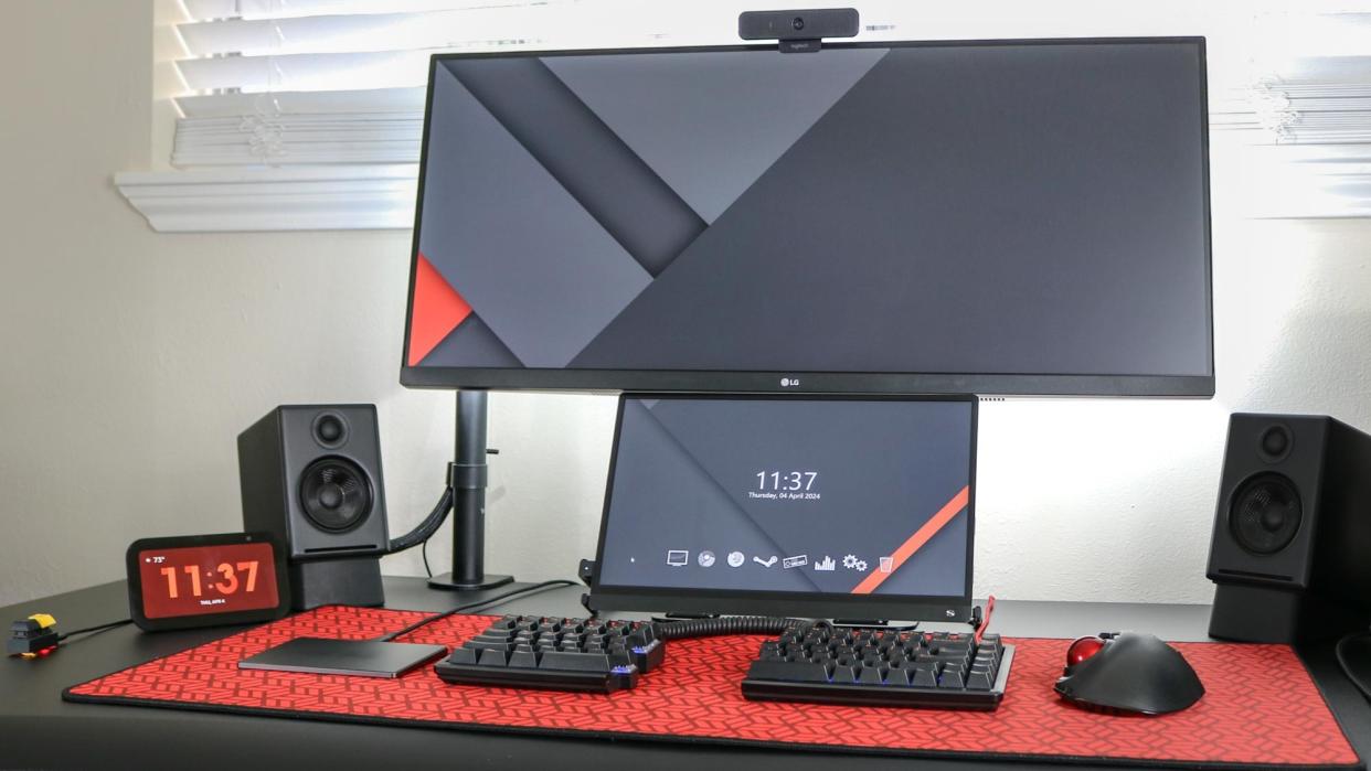  A picture of a desk setup with a trackpad on the left side of a split mechanical keyboard. 