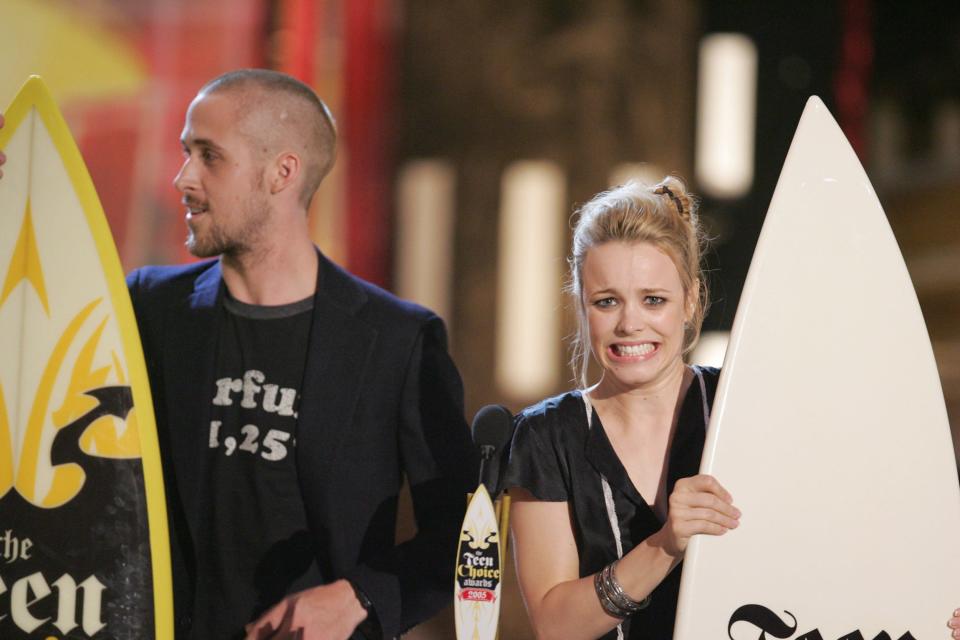 Ryan Gosling and Rachel McAdams holding surfboards