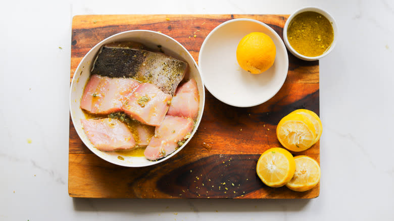 fish fillets in bowl and lemons