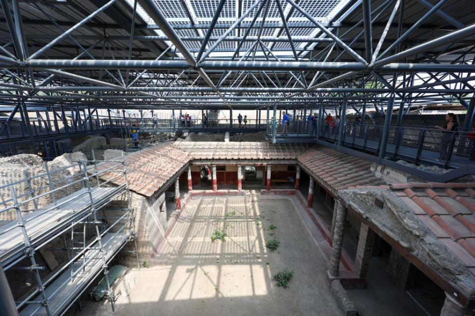 A public footpath with people on it above the Insula of the Chaste Lovers, in the archaeological excavations of Pompeii