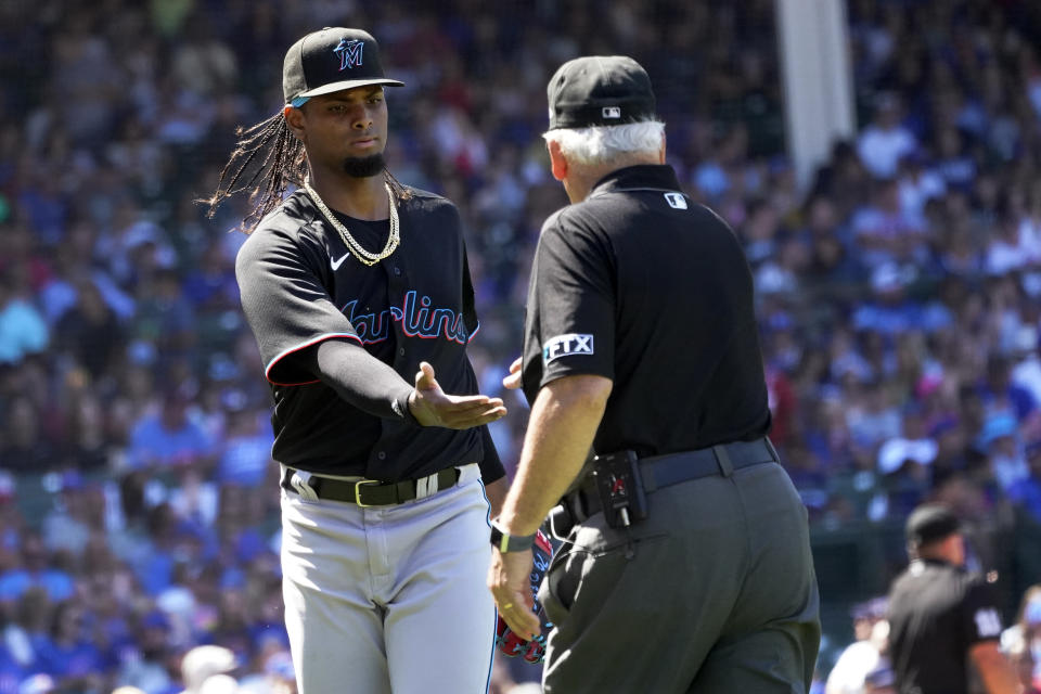 First base umpire Larry Vanover checks the pitching hand of Miami Marlins starting pitcher Edward Cabrera after the fourth inning of a baseball game against the Chicago Cubs Friday, Aug. 5, 2022, in Chicago. (AP Photo/Charles Rex Arbogast)