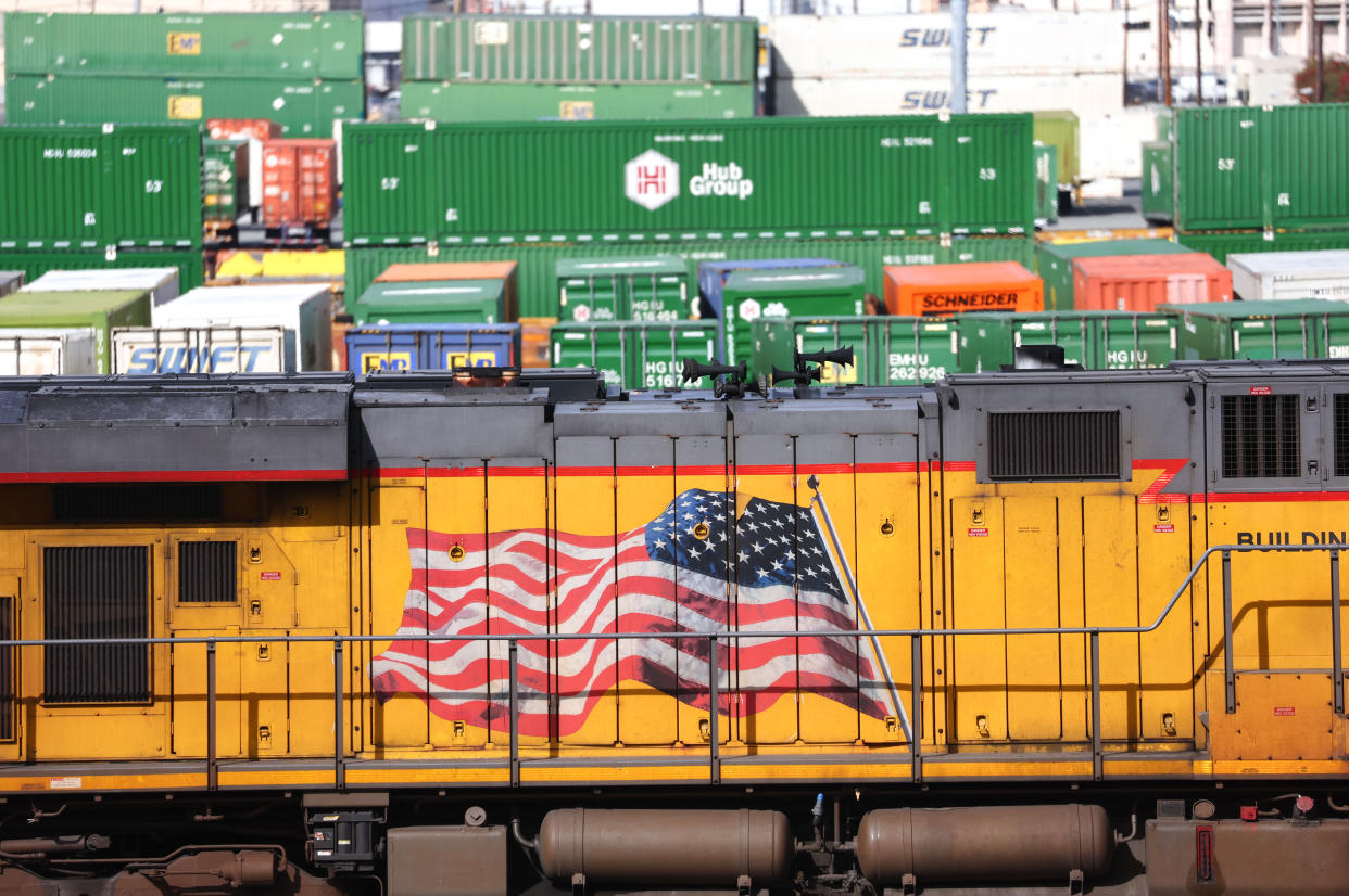A freight train engine and shipping containers are viewed in a Union Pacific Intermodal Terminal rail yard on November 21, 2022 in Los Angeles. (Photo by Mario Tama/Getty Images)
