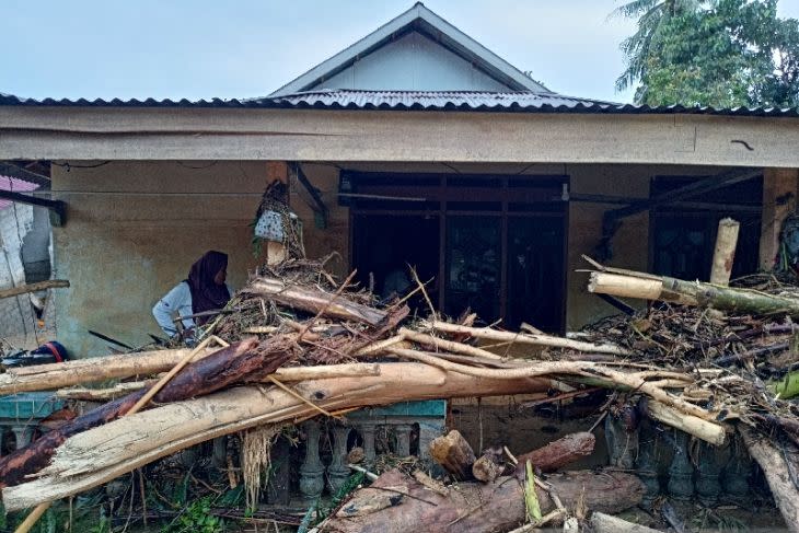 Salah seorang warga mengecek kondisi rumahnya yang dipenuhi tumpukan kayu akibat di hantam banjir pada Kamis (28/7) malam di Desa Torue, Kabupaten Parigi Moutong, Sulawesi Tengah, Jumat (29/7/2022). ANTARA/Moh Ridwan