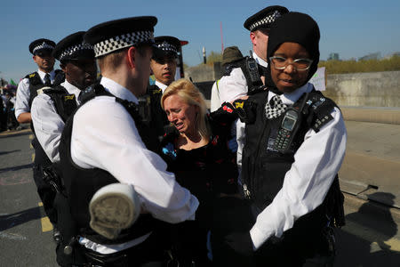 Foto del sábado de agentes de la policía deteniendo a una manifestante contra el cambio climático en el Puente Waterloo de Londres. Abr 20, 2019. REUTERS/Simon Dawson