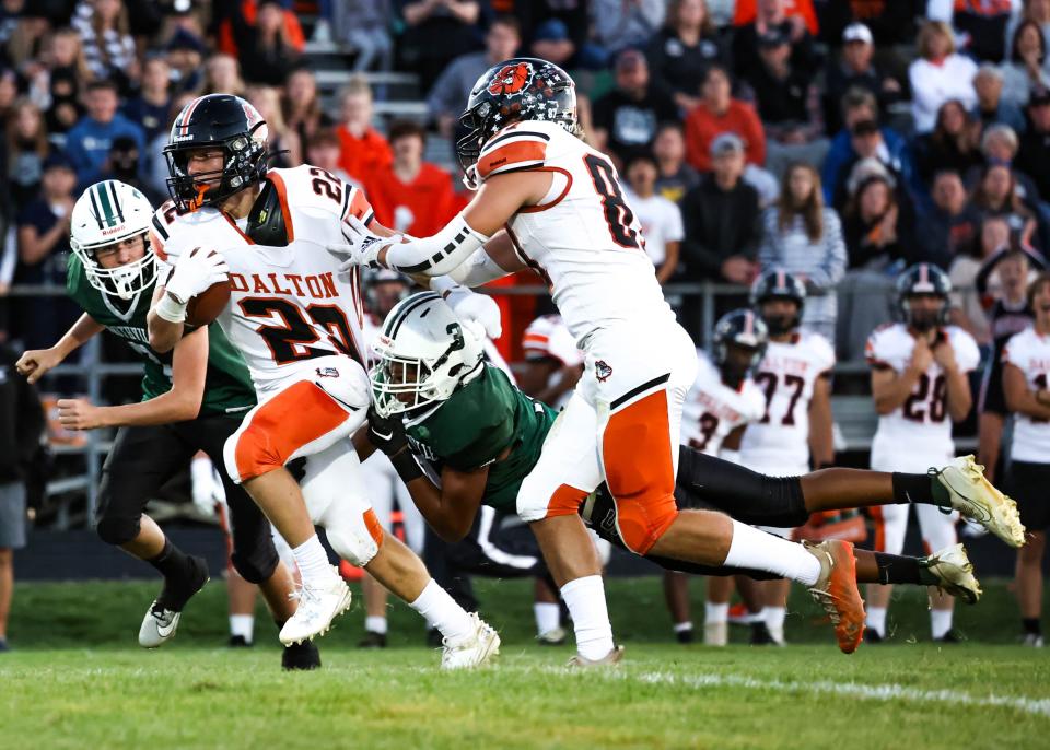 Dalton's Sammy Tomlinson keeps his legs churning for more yards as Smithville's Isaiah Beery tries to hang on and make the tackle.