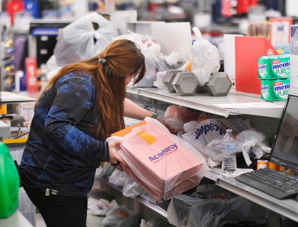 An employee arranges online orders for pickup during Black Friday shopping in 2021 at Academy Sports and Outdoors in Edmond.