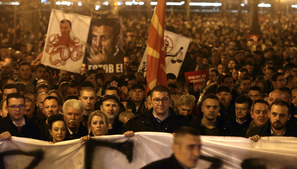 Hristijan Mickoski, center front, the leader of the opposition conservative VMRO-DPMNE party, takes a part in a protest march starting outside the Public Prosecutor's office and ending in front of the complex of national courts, in Skopje, North Macedonia, Tuesday, Feb. 25, 2020. Thousands of conservative opposition party supporters were marching in North Macedonia's capital Skopje late on Tuesday, accusing the outgoing leftist government for strongly influencing prosecution and court decisions. (AP Photo/Boris Grdanoski)