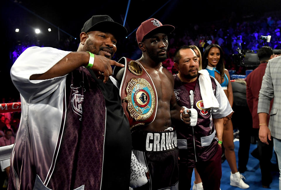 Terence Crawford, posing with his WBO welterweight belt after stopping Jeff Horn in June in Las Vegas, has signed a multi-year contract extension with Top Rank. (Getty Images)