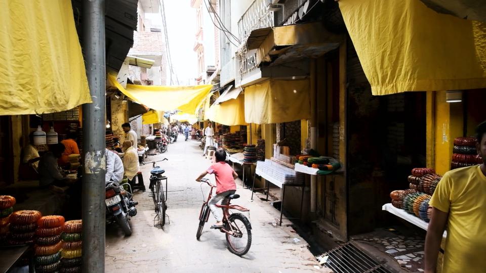 A boy rides his bike through a Firozabad street