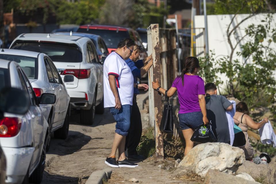 Beachgoers climb down a rocky path at La Costa Beach