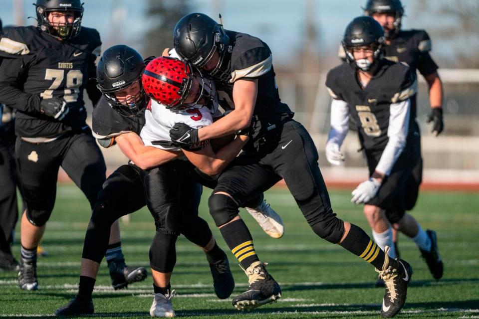 Mount Baker running back Marcques George is tackled by Royal’s Lance Allred (left) and Jared Lee (right) on a rush up the middle in the third quarter of the Class 1A state championship game in 2022.