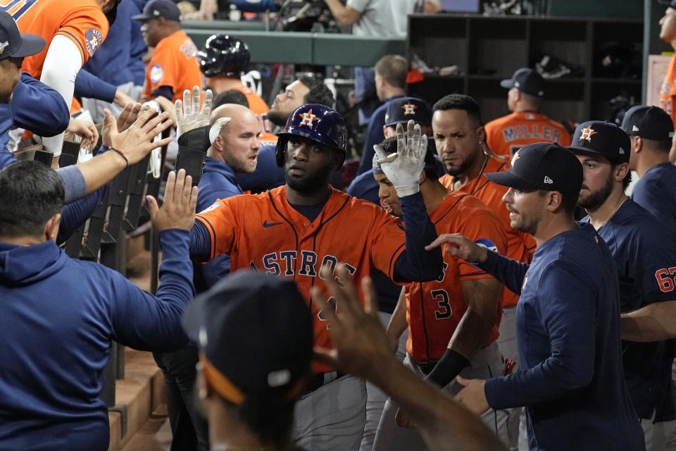 Houston Astros' Yordan Alvarez celebrates in the dugout after scoring against the Texas Rangers during the second inning in Game 3 of the baseball American League Championship Series Wednesday, Oct. 18, 2023, in Arlington, Texas. (AP Photo/Godofredo A. Vasquez)