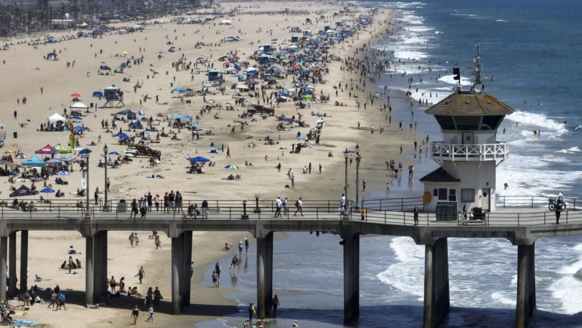 Beach-goers flock to the shore south of the pier in Huntington Beach, California on Friday. (Photo: Jeff Gritchen/The Orange County Register via AP)