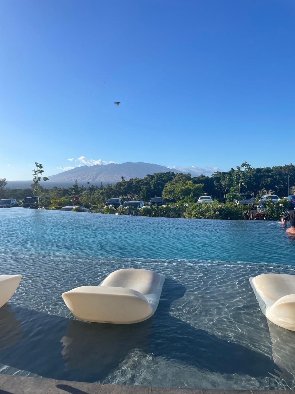 infinity pool in hawaii with mountains in the background