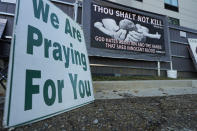 Among the least graphic signage used by anti-abortion activists are these two that face the parking lot of the Jackson Women's Health Organization, a state-licensed abortion clinic in Jackson, Miss., Wednesday, Dec. 1, 2021. A small group of anti-abortion activists stood outside the clinic in an effort to dissuade patients from entering. On Wednesday, the U.S. Supreme Court hears a case that directly challenges the constitutional right to an abortion established nearly 50 years ago. (AP Photo/Rogelio V. Solis)