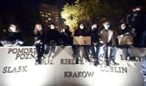 Protesters gather outside the parliament in Warsaw, Poland, Wednesday Oct. 28, 2020. People across Poland stayed off their jobs and huge crowds poured onto the streets for a seventh straight day of protests Wednesday, enraged over a top court ruling that bans abortions in cases of fetal abnormalities.(AP Photo/Czarek Sokolowski)