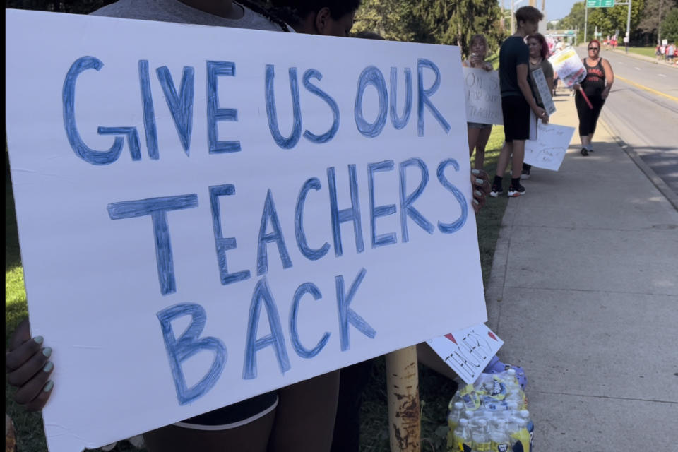 Teachers march on sidewalks outside Whetstone High School in Columbus, Ohio, as part of a district-wide teacher's strike on Wednesday, Aug. 24, 2022. A strike by teachers in Ohio's largest school district entered its third day Wednesday — the first day of school for some 47,000 students, with some of those students and their parents rallying to their sides. (AP Photo/Samantha Hendrickson)