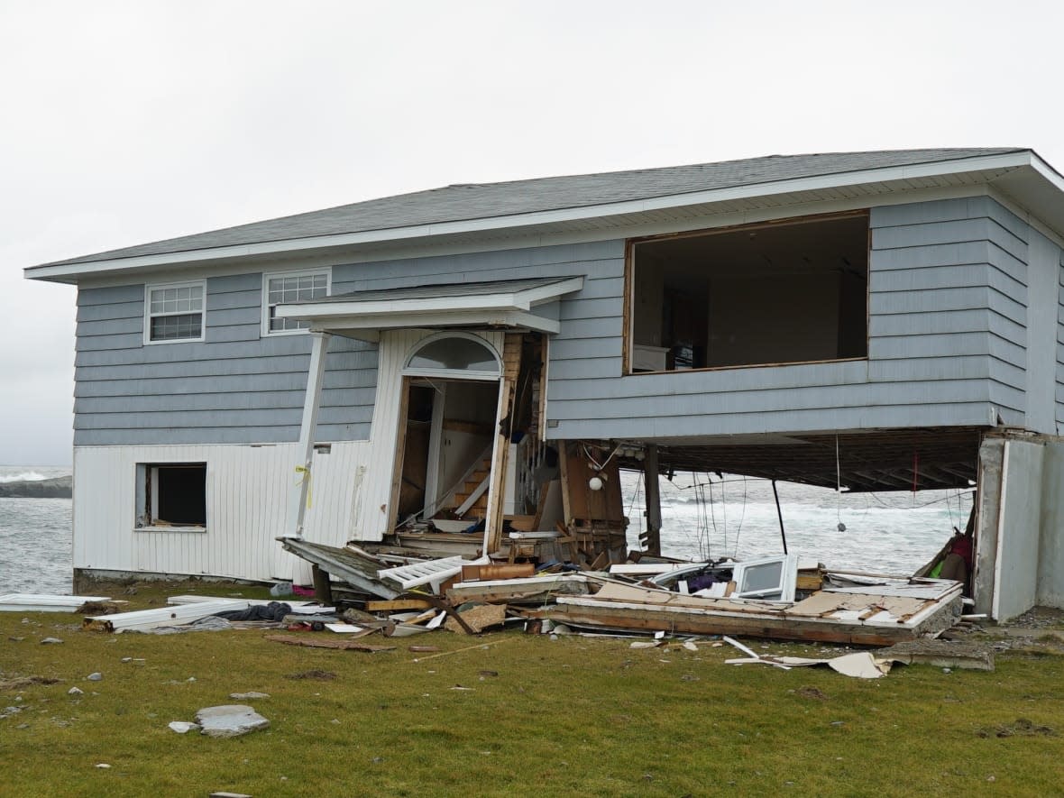 One of the homes heavily damaged by Fiona still stands three months later in Port aux Basques, N.L. Several condemned properties have yet to be demolished. (Waqas Chughtai/CBC News - image credit)