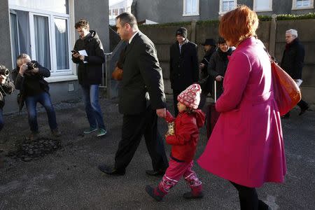 Ex-soldier Rob Lawrie walks hand-in hand with Afghani girl Bahar Ahmadi, known as Bru, as they arrive at the news conference in Boulogne-sur-Mer, France, January 14, 2016. REUTERS/Benoit Tessier