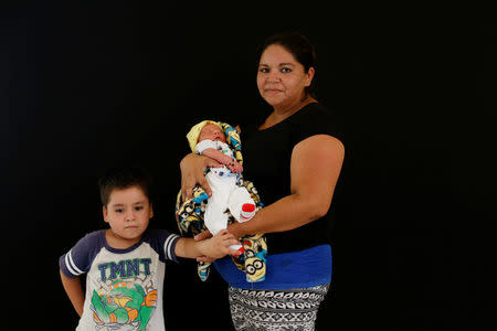 Concepcion Bautista, 39, from Guatemala poses for a photograph with her newborn baby and her son at a migrant shelter, known as The 72, in Tenosique, Tabasco, Mexico. Bautista fled Guatemala after gang members threatened to kill her and seized her home, demanding money to give it back. Her ultimate goal is to reunite with her father and two sons up north, but for the time being, she believes applying for asylum in Mexico is smarter than trying to break into Trump's United States. "I'm not going back to Guatemala," she said. "I have faith that we'll be able to cross but for now, at least, I'm staying in Mexico." REUTERS/Carlos Jasso