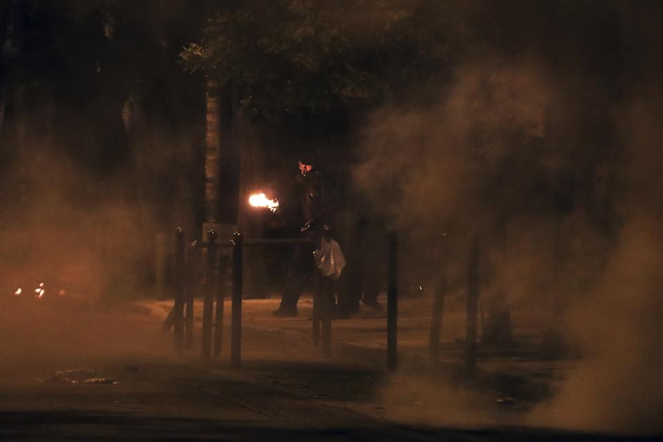 A man prepares to throw a petrol bomb at riot police during clashes in the Athens neighborhood of Exarchia, a haven for extreme leftists and anarchists, Saturday, Nov. 17, 2018. Clashes have broken out between police and anarchists in central Athens on the 45th anniversary of a student uprising against Greece's then-ruling military regime. (AP Photo/Yorgos Karahalis)