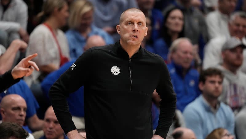 BYU head coach Mark Pope watches during the first half of an NCAA college basketball game against Kansas Tuesday, Feb. 27, 2024, in Lawrence, Kan. (AP Photo/Charlie Riedel)