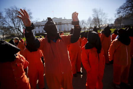 Protesters in orange jumpsuits, including one in plastic shackles, from organizations including Amnesty International USA rally outside the White House to demand the closure of the U.S. prison at Guantanamo Bay, in Washington, January 11, 2016. REUTERS/Jonathan Ernst