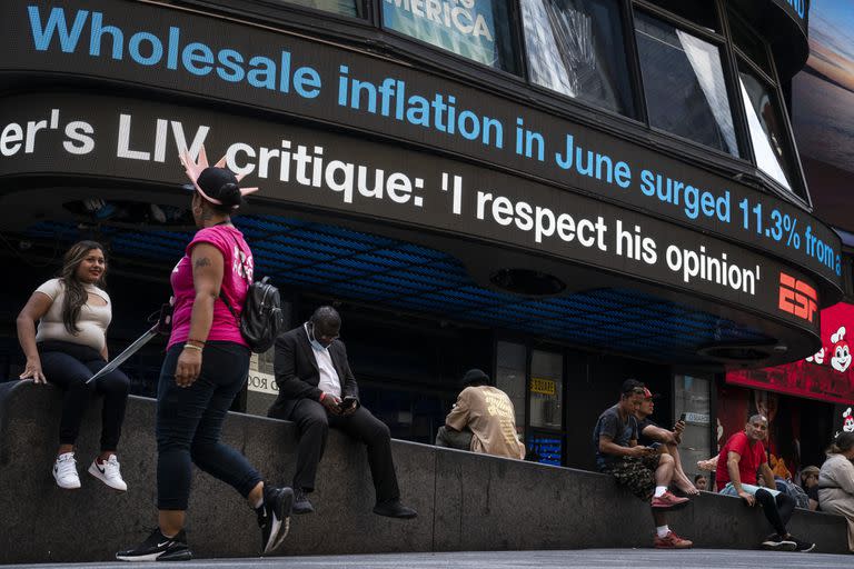 Un cartel muestra los carteles con los índices de inflación en Times Square. (AP Photo/John Minchillo