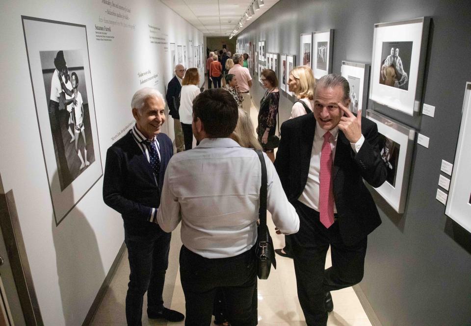 Photographer Steven Caras (l) chats with people during the opening of the CARASMATIC: THROUGH THE LENS OF A DANCER photography exhibit at the Kravis Center, which features images from Caras' personal archive, Thursday December 8, 2022.