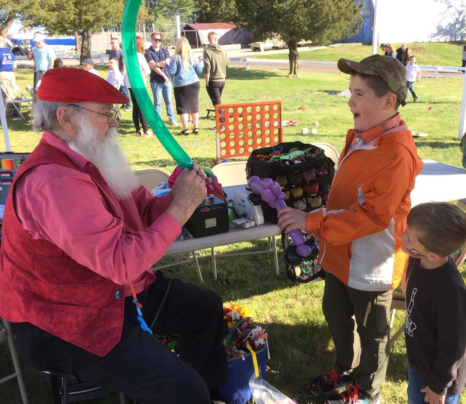 “Bjorn the Magician”, aka John Slack, twists balloon creatures for delighted youngsters.