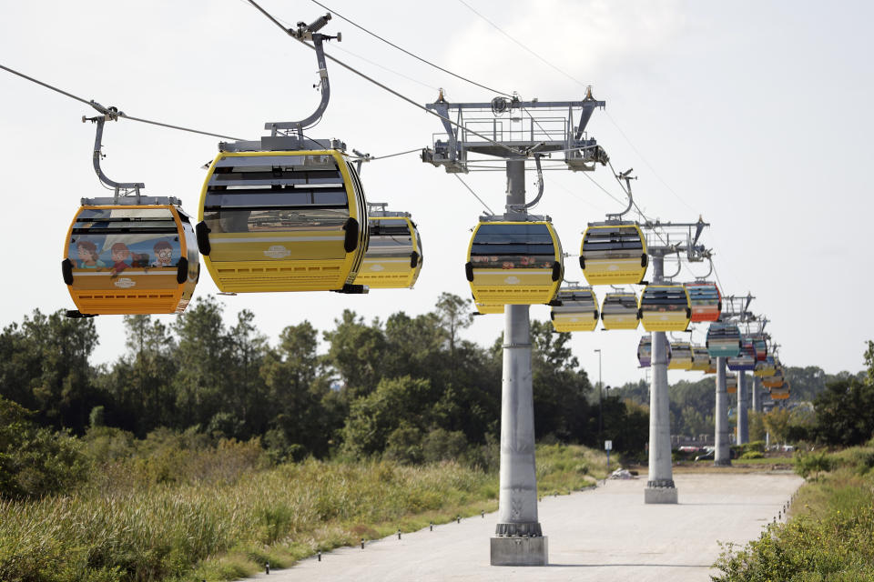 Gondolas move to various locations at Walt Disney World on the Disney Skyliner aerial tram, Friday, Sept. 27, 2019, in Lake Buena Vista, Fla. The Disney Skyliner gondolas opening to visitors on Sunday are the latest addition to one of the largest private transportation systems in the U.S.(AP Photo/John Raoux)