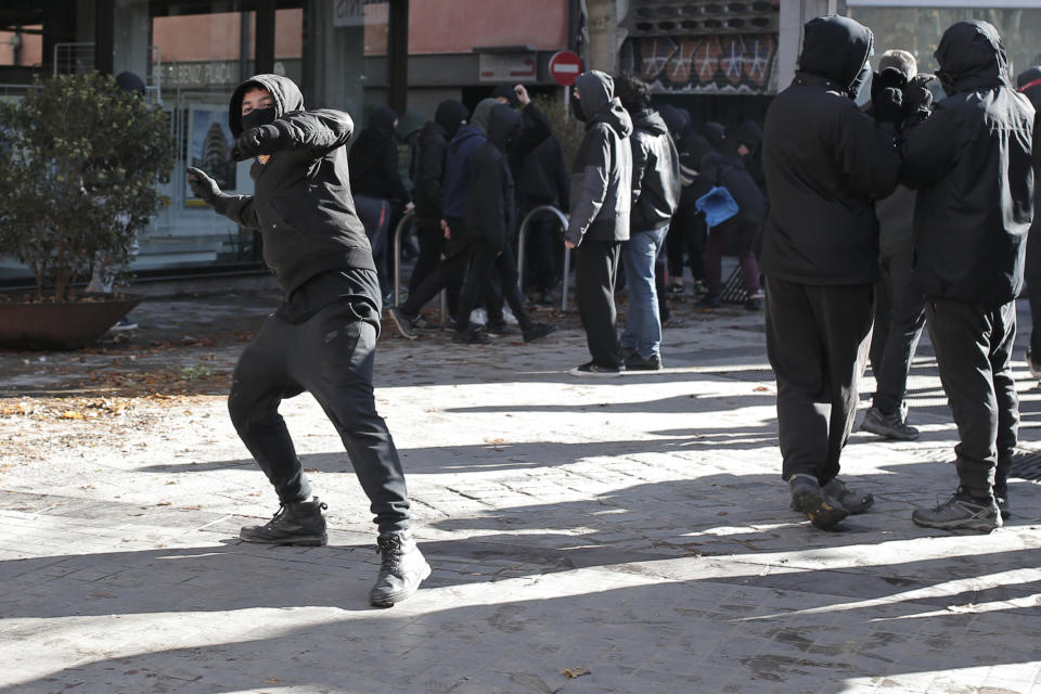 A demonstrators throws a stone while protesting the presence of the far-right party VOX who held a meeting on Constitution Day in Girona, Spain, Friday Dec. 6, 2019. The biggest change emerging from the Nov. 10 election was the resurgence of extreme Spanish nationalism in the form of the far-right Vox party that won 52 seats to become Spain's third parliamentary force. (AP Photo/Joan Mateu)