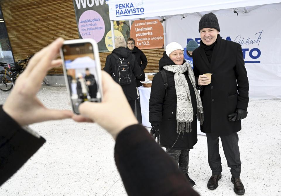 Member of Greens Party, presidential candidate Pekka Haavisto, right, has a photo taken with Minna Joentakanen during campaigning in Helsinki, Finland on December 16, 2023. The first round of the Finnish presidential election will take place on January 28. (Vesa Moilanen/Lehtikuva via AP)