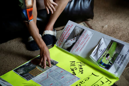 Maritza Lopez points to a poster she displayed at a Citgo community appreciation picnic in order to spread awareness about lead contamination and available resources, while speaking to a reporter in her home in East Chicago, Indiana, U.S. September 16, 2016. REUTERS/Michelle Kanaar