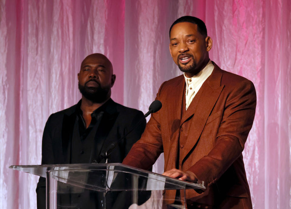 Will Smith speaking at a podium.