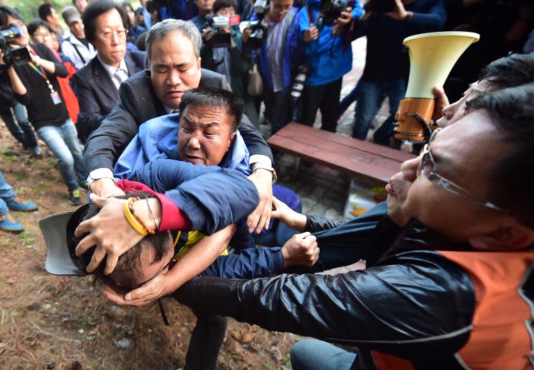 A South Korean resident (left) scuffles with activists as he tries to block the launch of balloons carrying propaganda leaflets from the border city of Paju, north of Seoul, on October 25, 2014