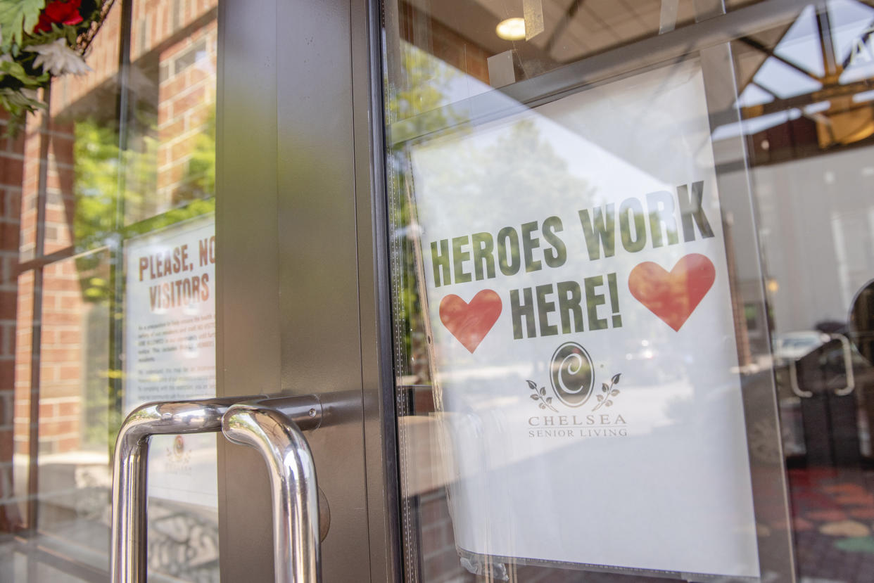 A sign reading "Heroes Work Here" is displayed in a window of the Maple Pointe Assisted Living facility in Rockville Centre, New York, on June 9