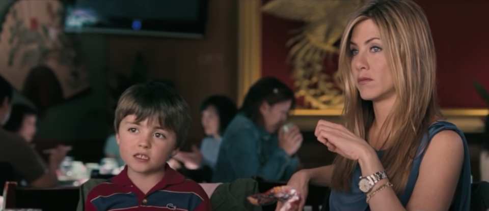 Jennifer and her son looking at Jason Bateman at dinner